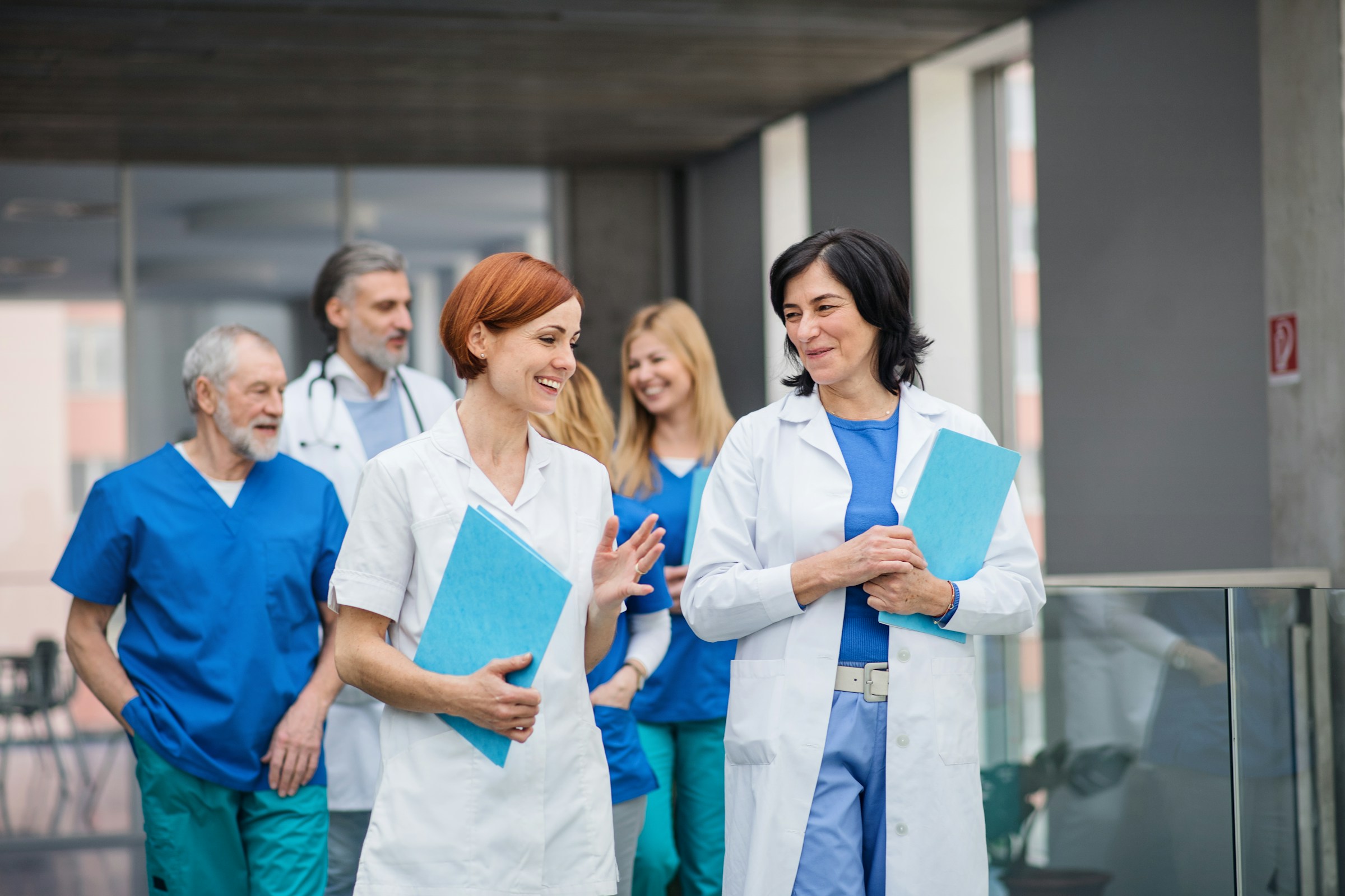 Clinicians walking together with patient charts